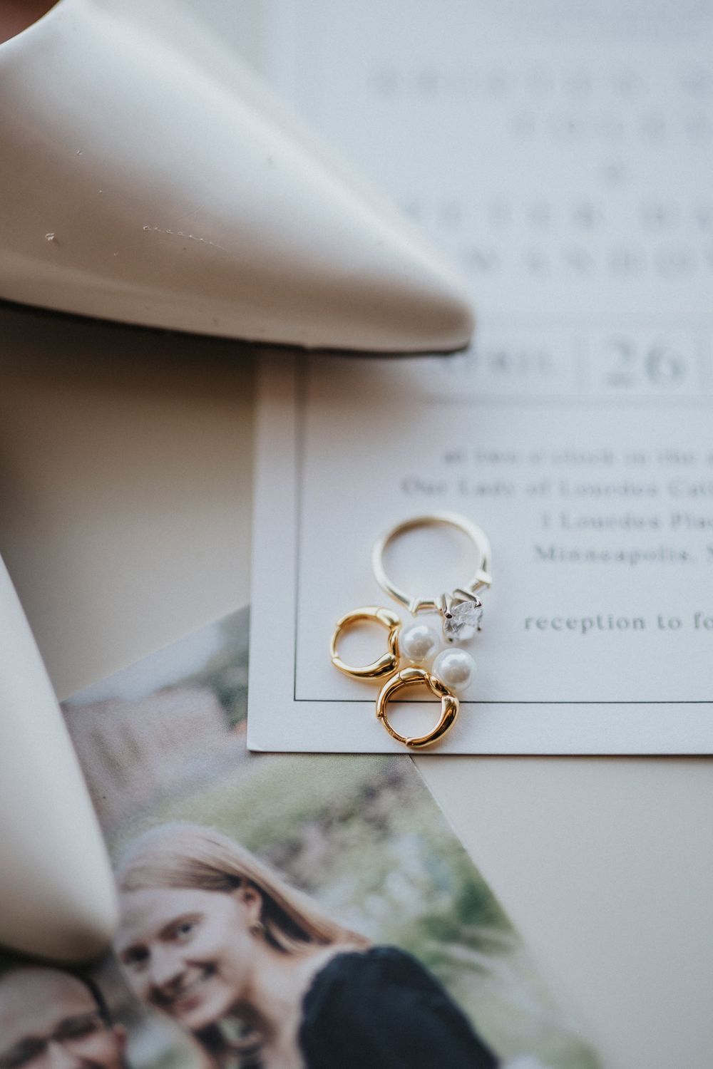 Wedding rings and invitation details photographed in soft natural light with elegant styling.