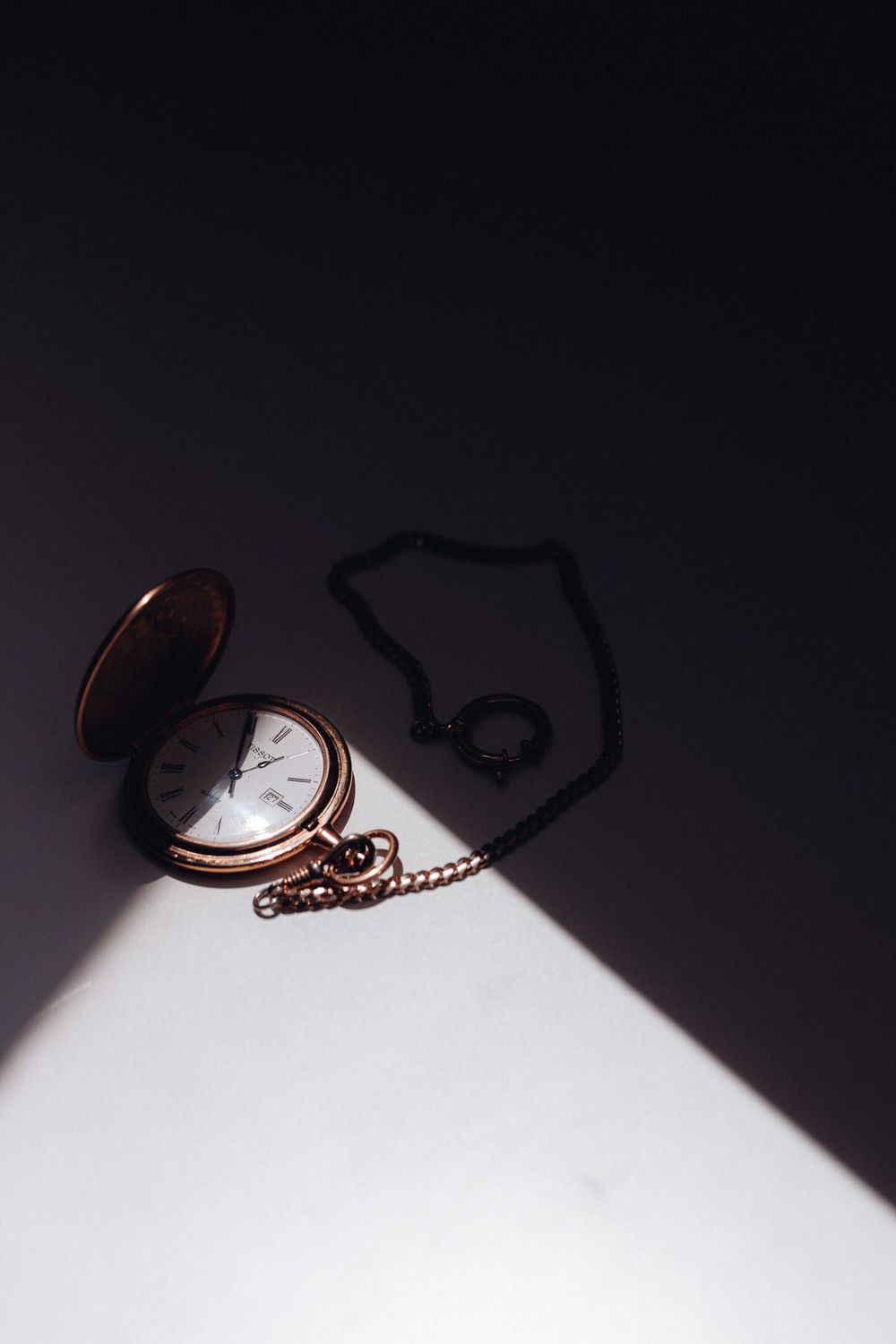 Taschenuhr im Licht mit Ring – stilles Symbol für Zeit, Erinnerung und das Versprechen einer Hochzeit.
