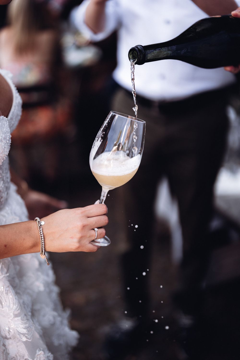 Champagner wird ins Glas eingeschenkt beim Hochzeitsempfang – elegantes Detail eines festlichen Moments.