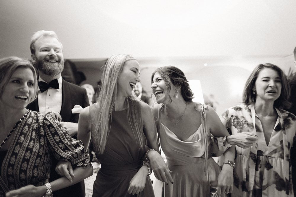 Lachende Hochzeitsgäste auf der Feier – echte Emotionen, Nähe und ausgelassene Stimmung während der Hochzeit.