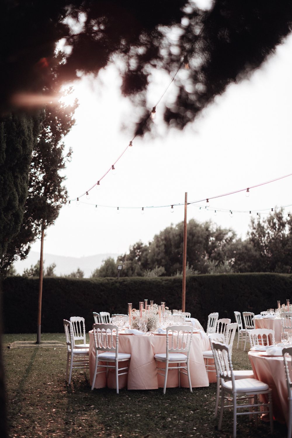 Elegantes Hochzeitsdinner im Garten mit Lichterkette – stilvolle Tischdekoration und warme Abendstimmung.