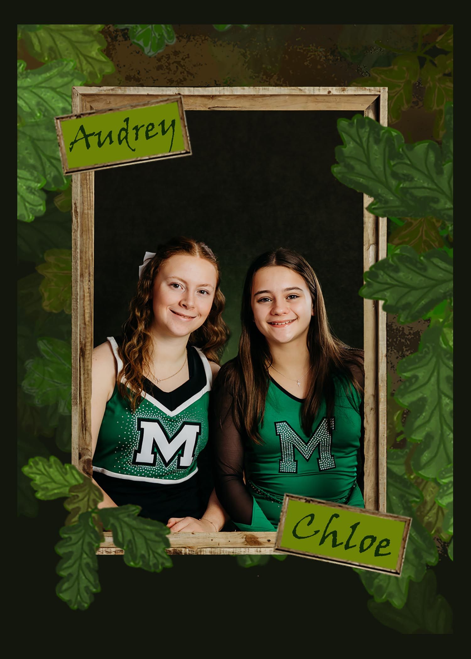 Two cheerleaders in green and white uniforms pose together in a wooden frame against a leafy background.