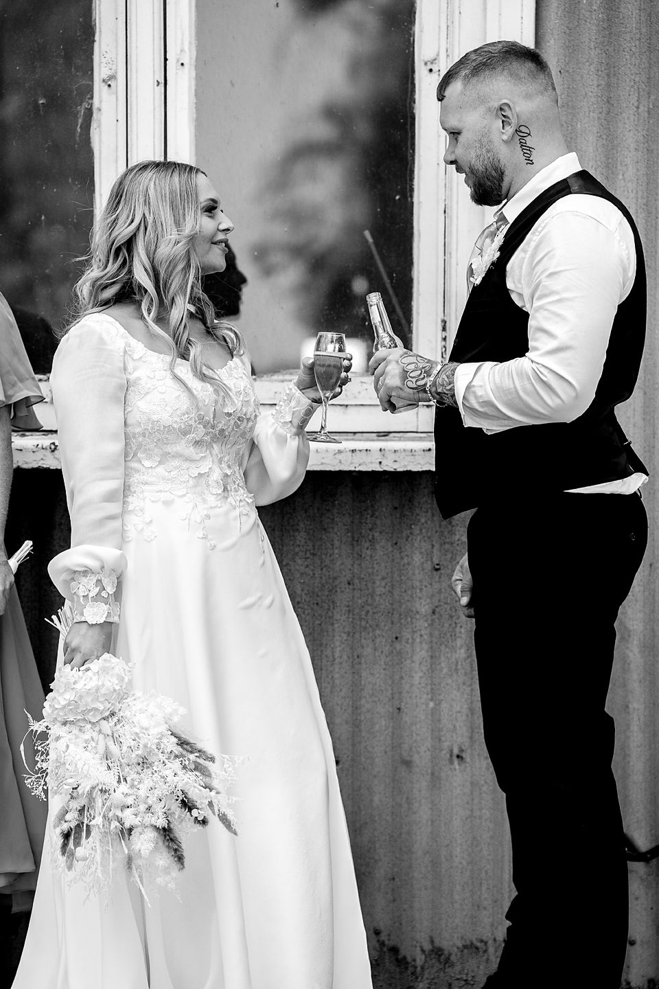 A sequence of four black and white wedding photos showing a couple in formal attire sharing intimate moments at a rustic venue.
