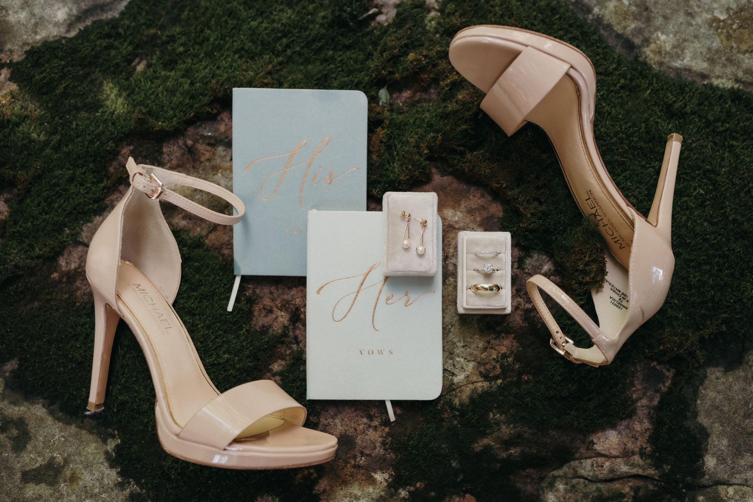 A collection of elegant nude heels and wedding stationery arranged artistically against a textured background.