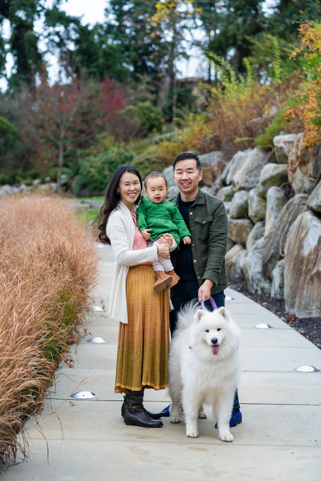 Family posing with their baby and dog for a photo.