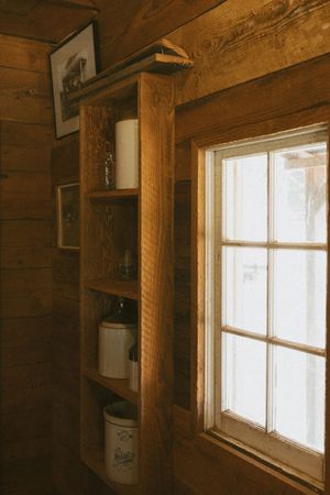 Rustic wooden interior with sunlight streaming through windows in a cabin or barn.