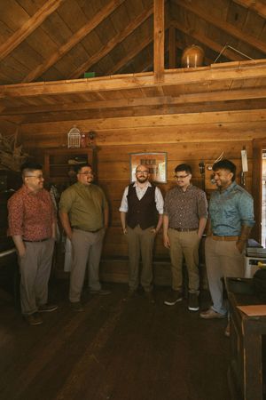Group gathered in a rustic wooden room with exposed beams and natural lighting.