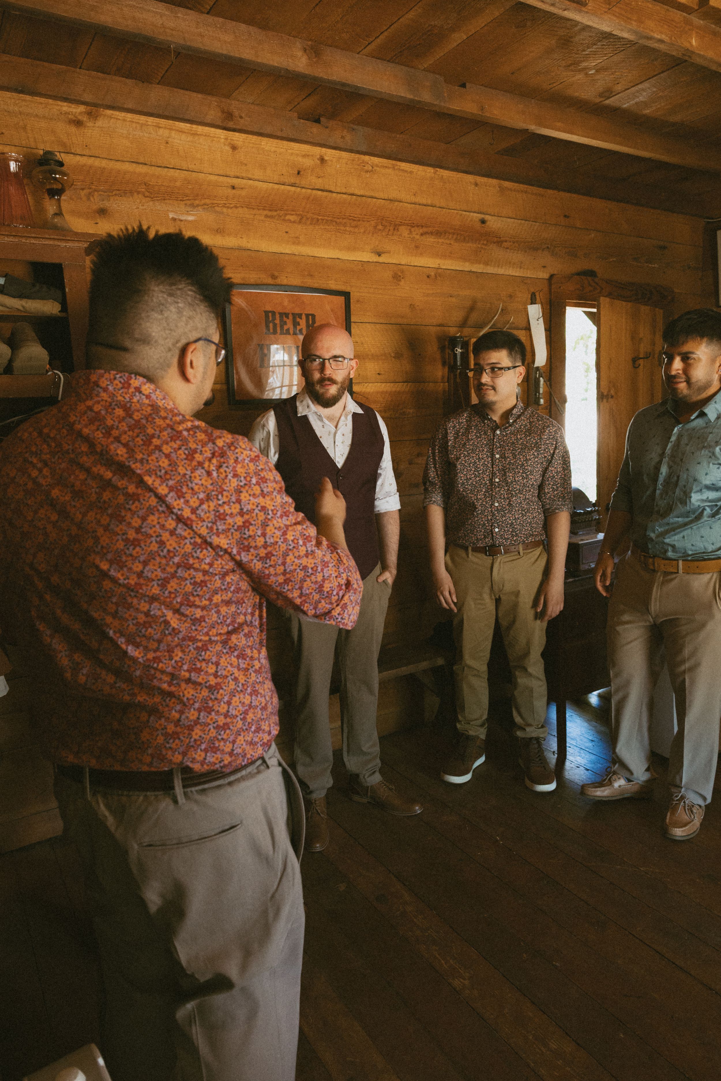 Group standing in a dimly lit wooden cabin interior.