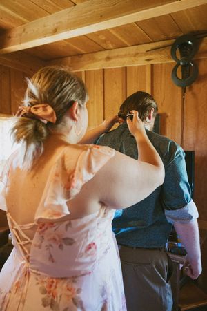 Wedding preparation scene in a rustic wooden room with natural lighting.