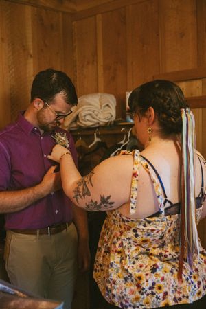 Wedding preparations underway in a rustic cabin setting with floral details.