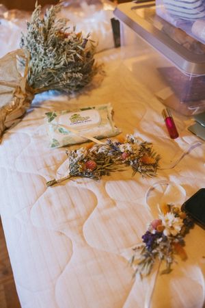 Dried flowers and wedding decorations arranged on a white tablecloth.