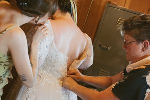 A series of photos showing the intricate process of lacing up and adjusting a white wedding dress.