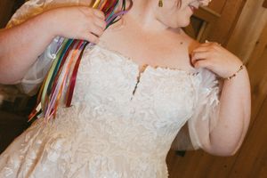 Close-up details of delicate white lace and beading on a wedding dress bodice.