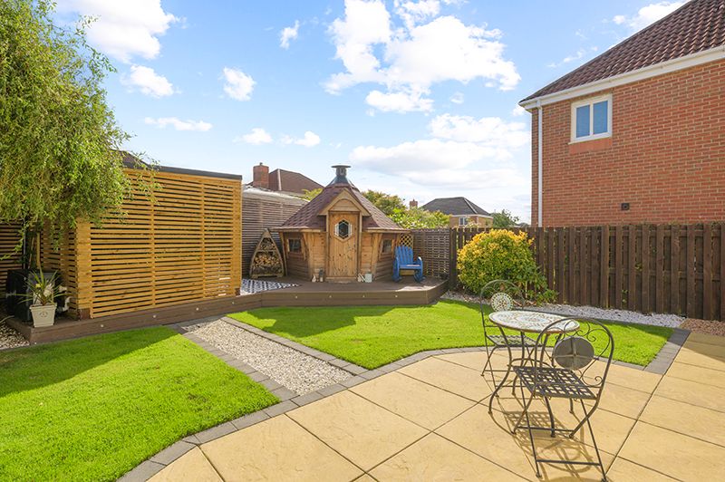 A series of backyard patio spaces with wooden fences, outdoor furniture, and landscaping features in a residential setting.