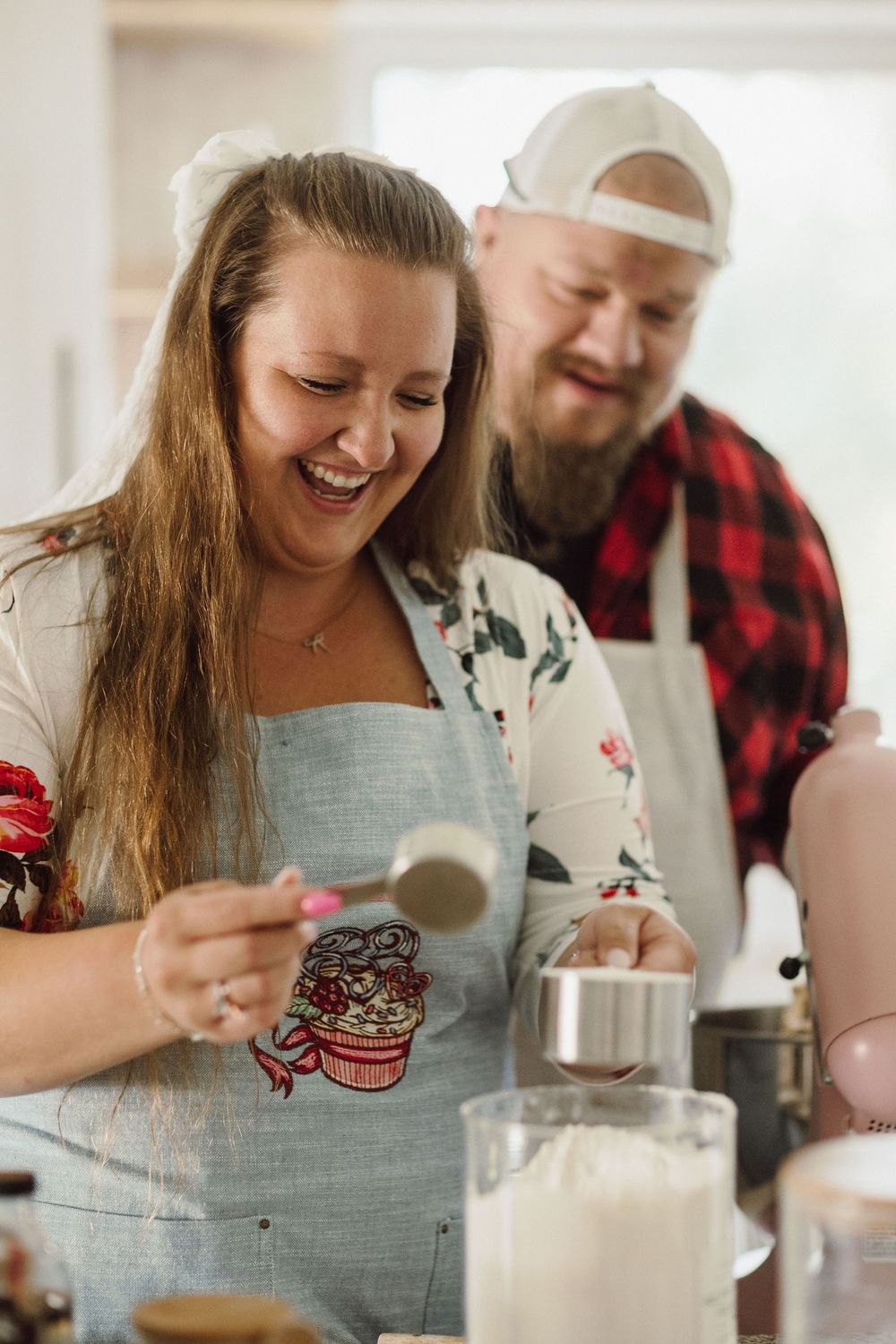 A couple shares a joyful moment in the kitchen while enjoying Oreo cookies and milk.