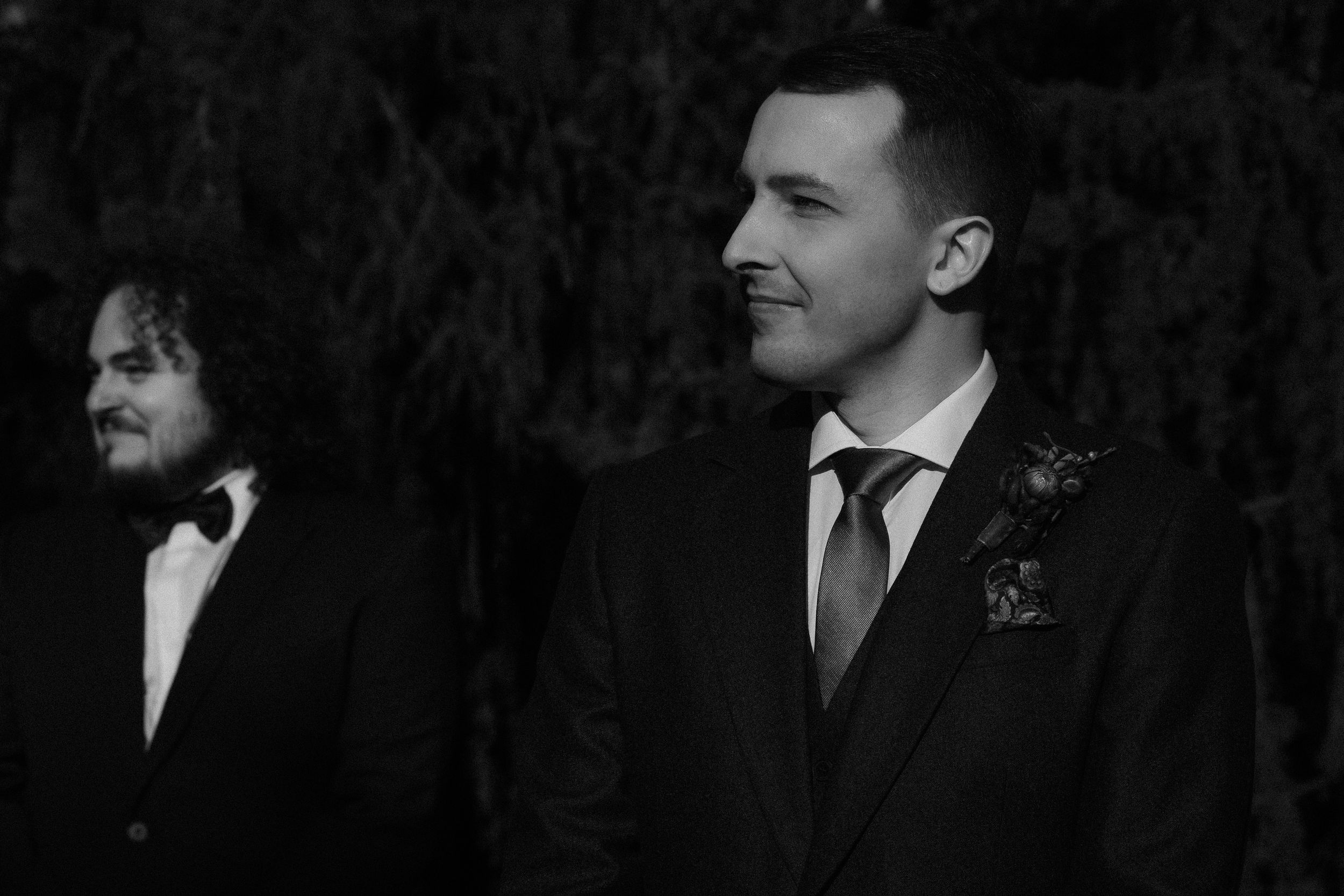 A series of black and white portraits of people in formal business attire against a dark background.