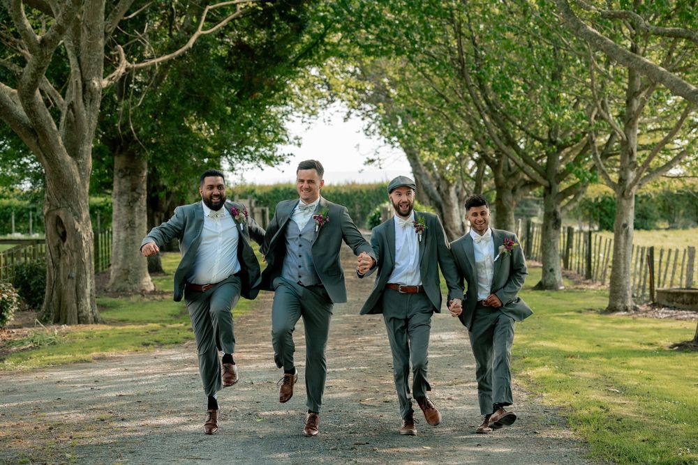 Students in school uniforms run and walk together on a tree-lined path during what appears to be a school day.