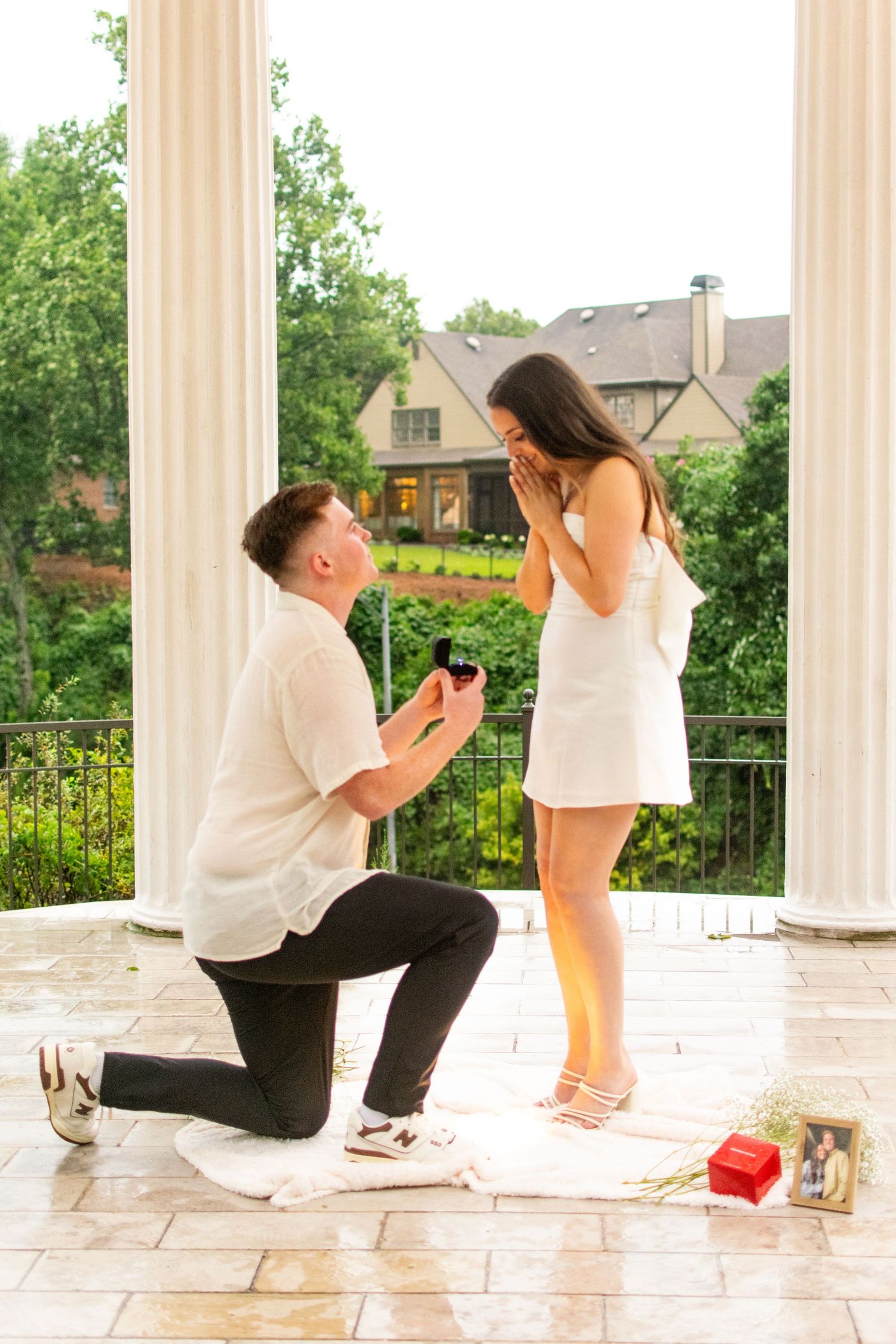 A surprise proposal moment on a columned porch with decorative elements.
