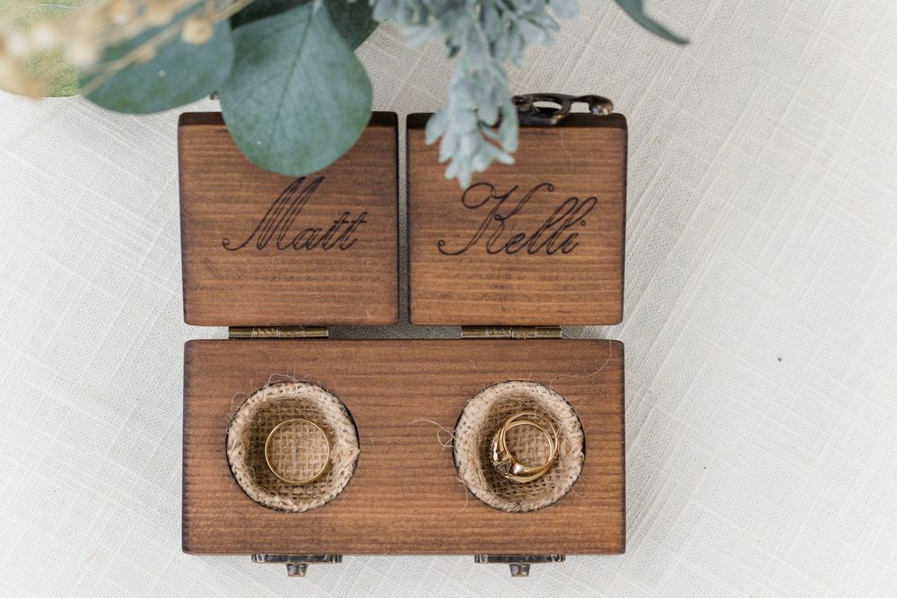 Wooden jewelry display boxes with ring holders arranged in a rustic style on a white surface.