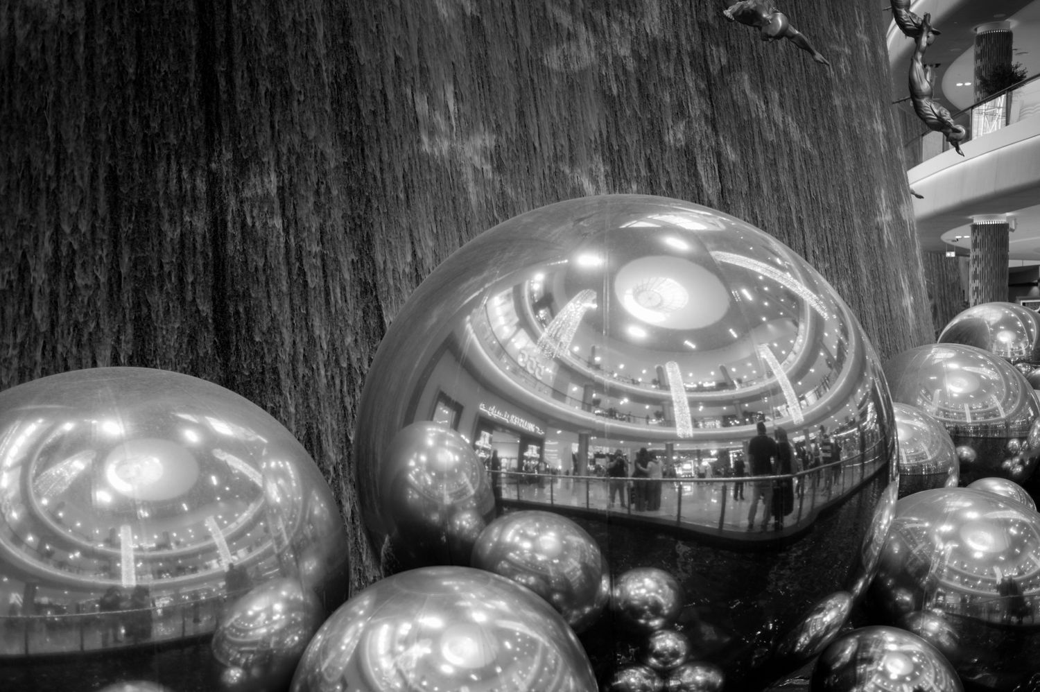 Dramatic black and white architectural shots of modern glass and metal building interiors with curved ceilings and lighting.