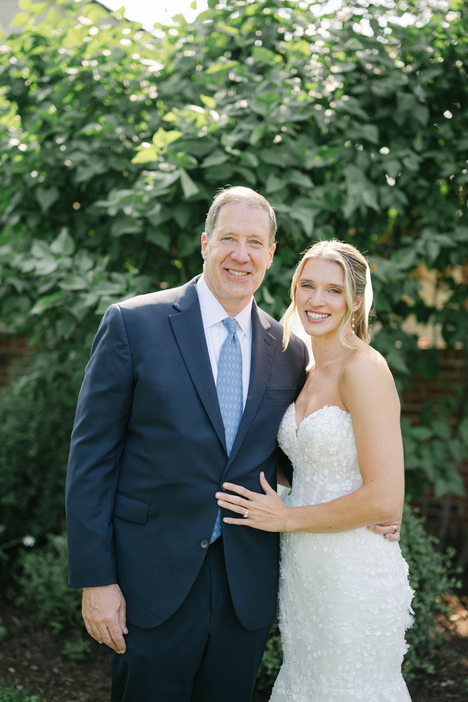 A couple in wedding attire share joyful moments together outdoors with greenery in the background. - Elawa Farm