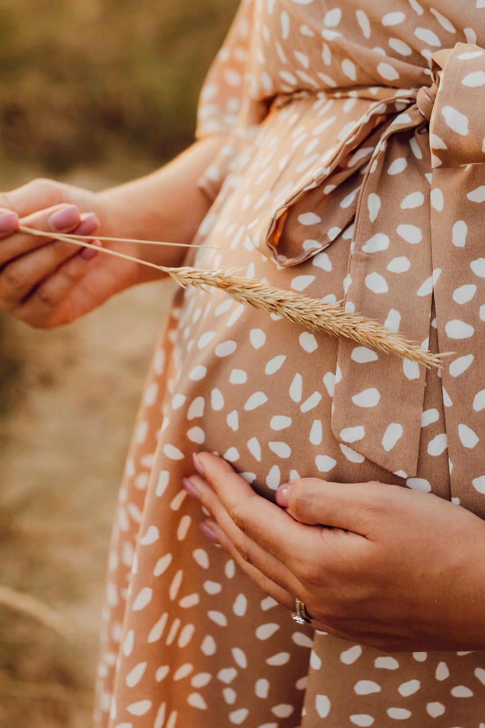 Close-up maternity photo highlighting baby bump at golden hour on Southbourne Beach, Dorset