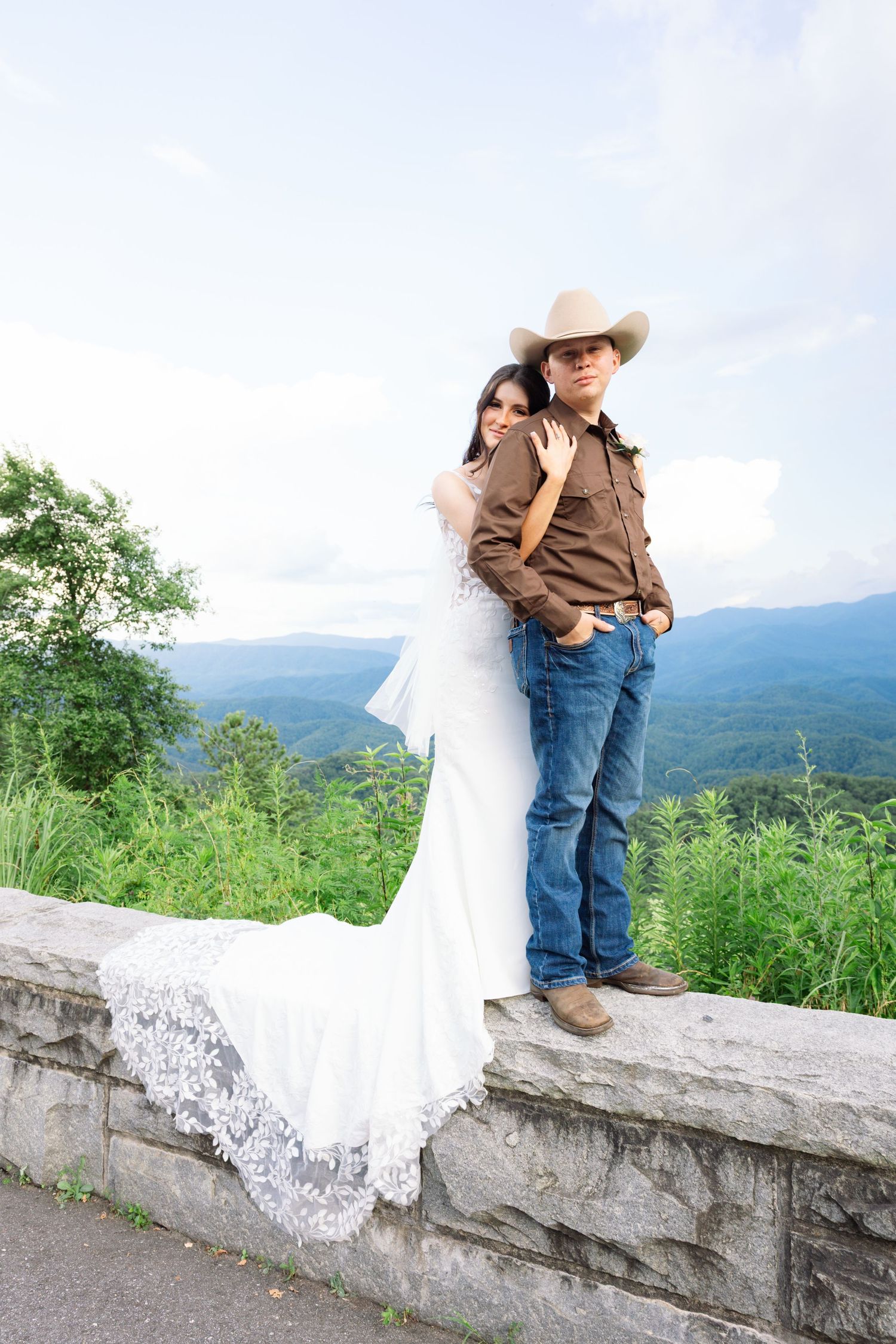 A series of four photos showing a child in cowboy attire sitting on a stone wall with mountains in the background.