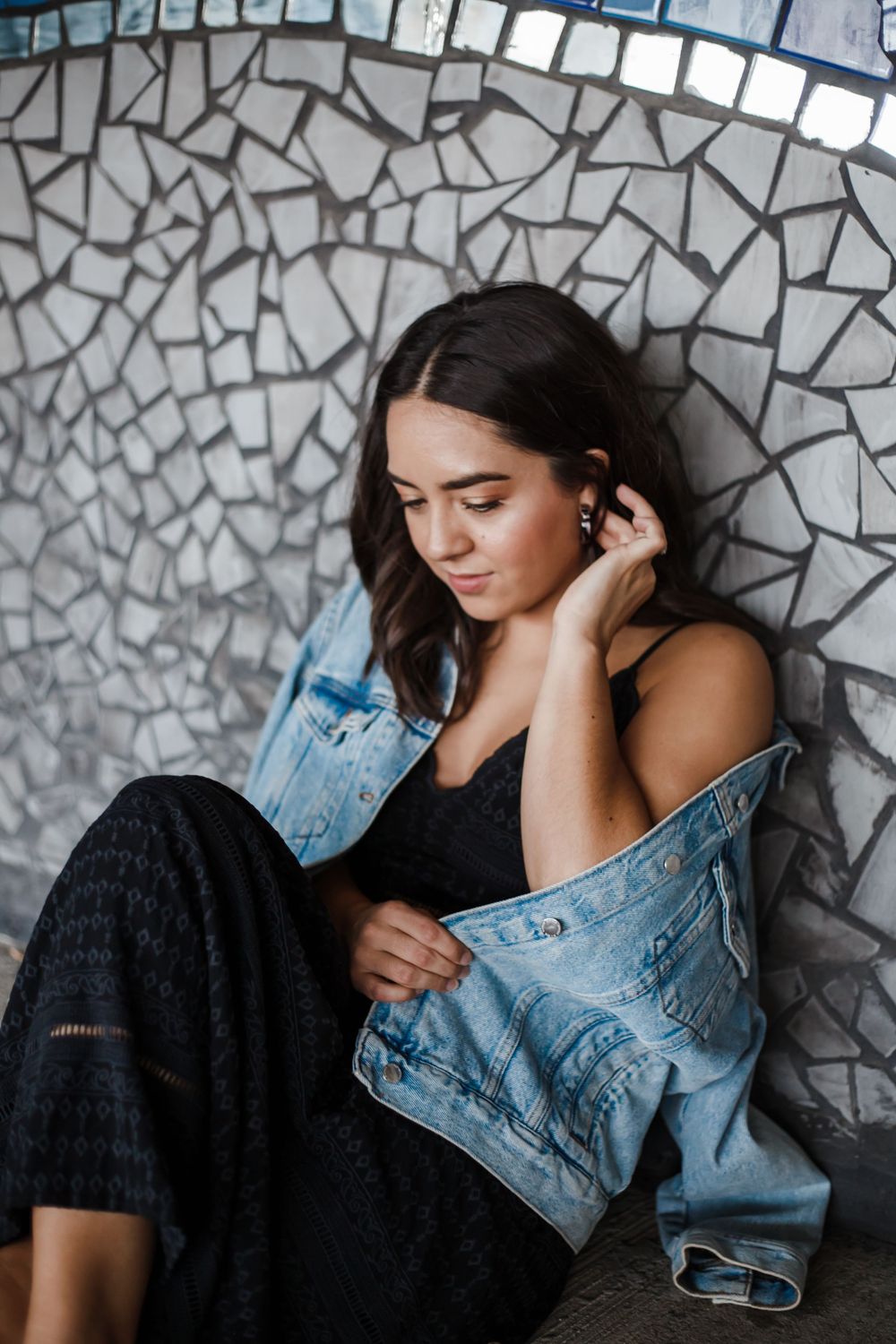 Artistic portrait series against a white mosaic wall featuring denim and black clothing styling.