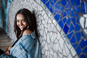 Fashion portraits against a vibrant blue mosaic wall with artistic tile patterns.