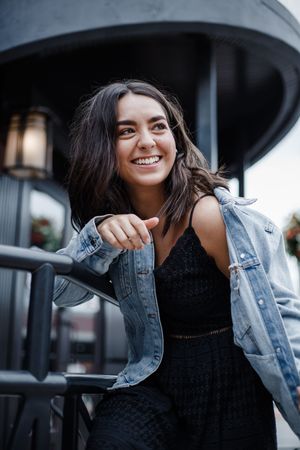 Fashion portraits against an urban backdrop featuring a black dress and denim jacket combination.