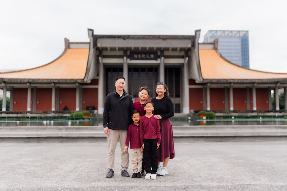 Group of people posing in front of traditional Asian architecture and temple buildings.