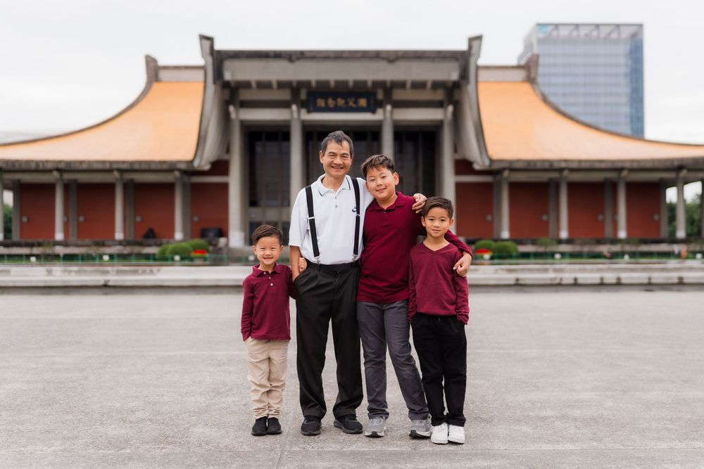 Children play and pose together in a traditional Asian courtyard with temple architecture in the background.