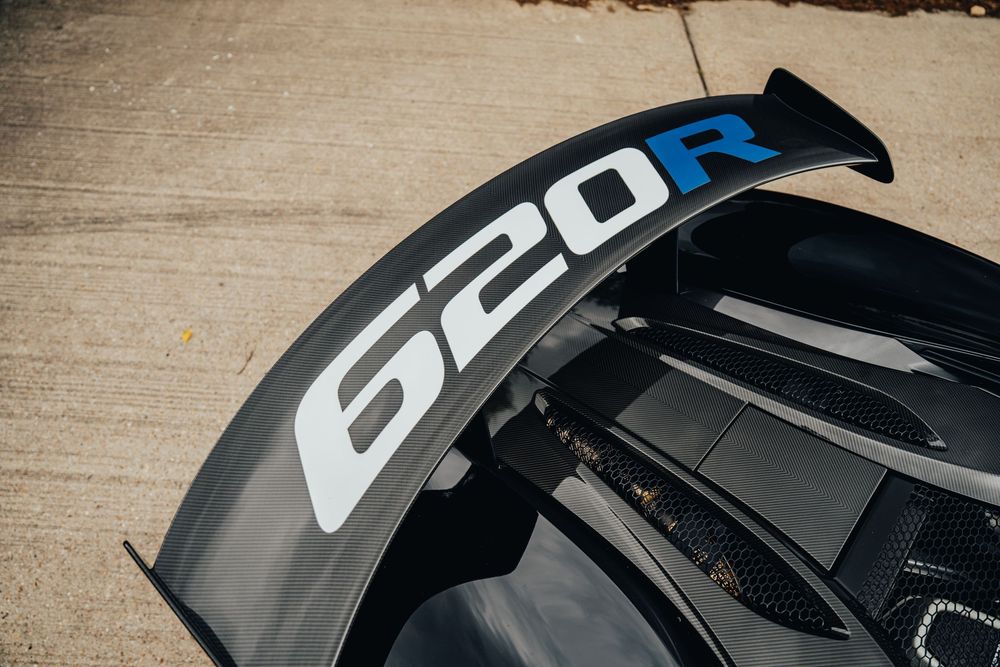 Close-up view of a black BMW 620R badge on a car's exterior panel.