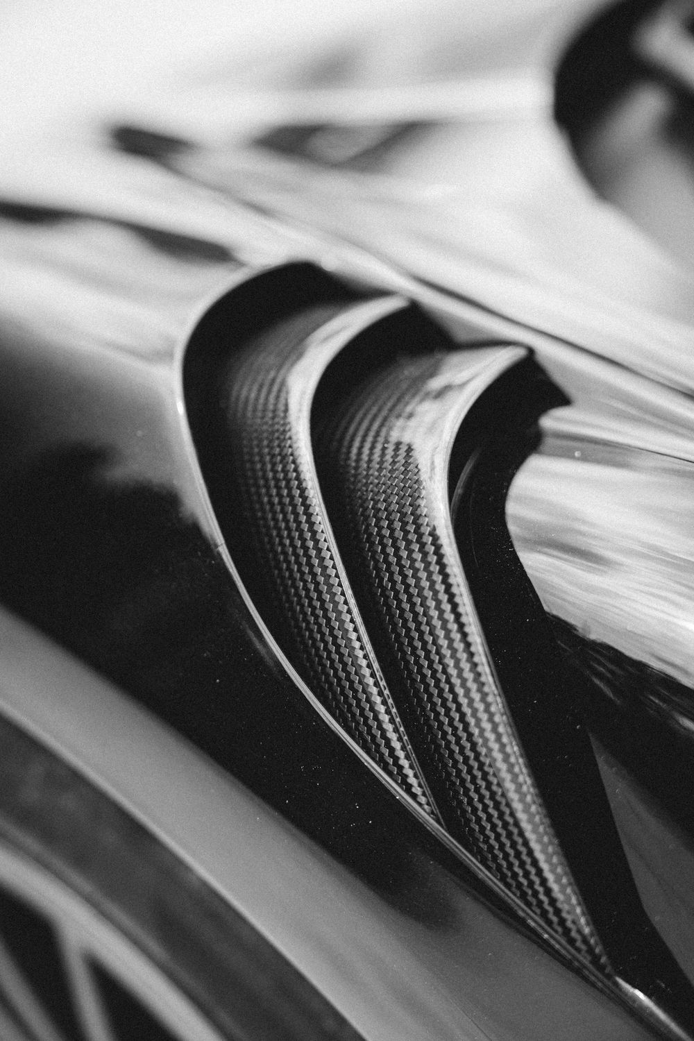 Close-up black and white photo of a curved book spine showing textural detail and shadows.