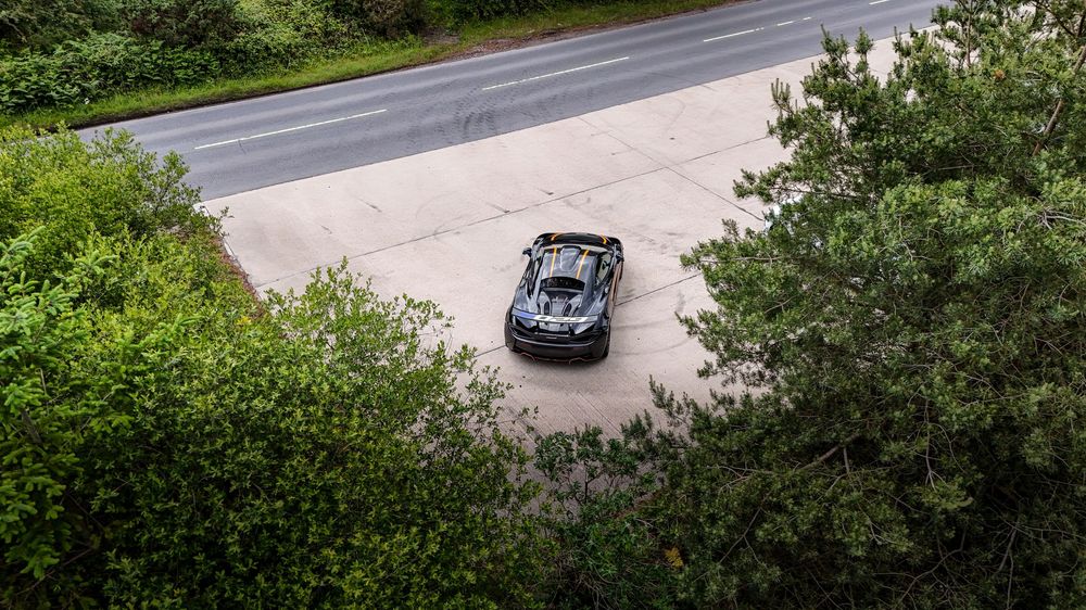 Panoramic view of a winding mountain road surrounded by lush green vegetation and trees.