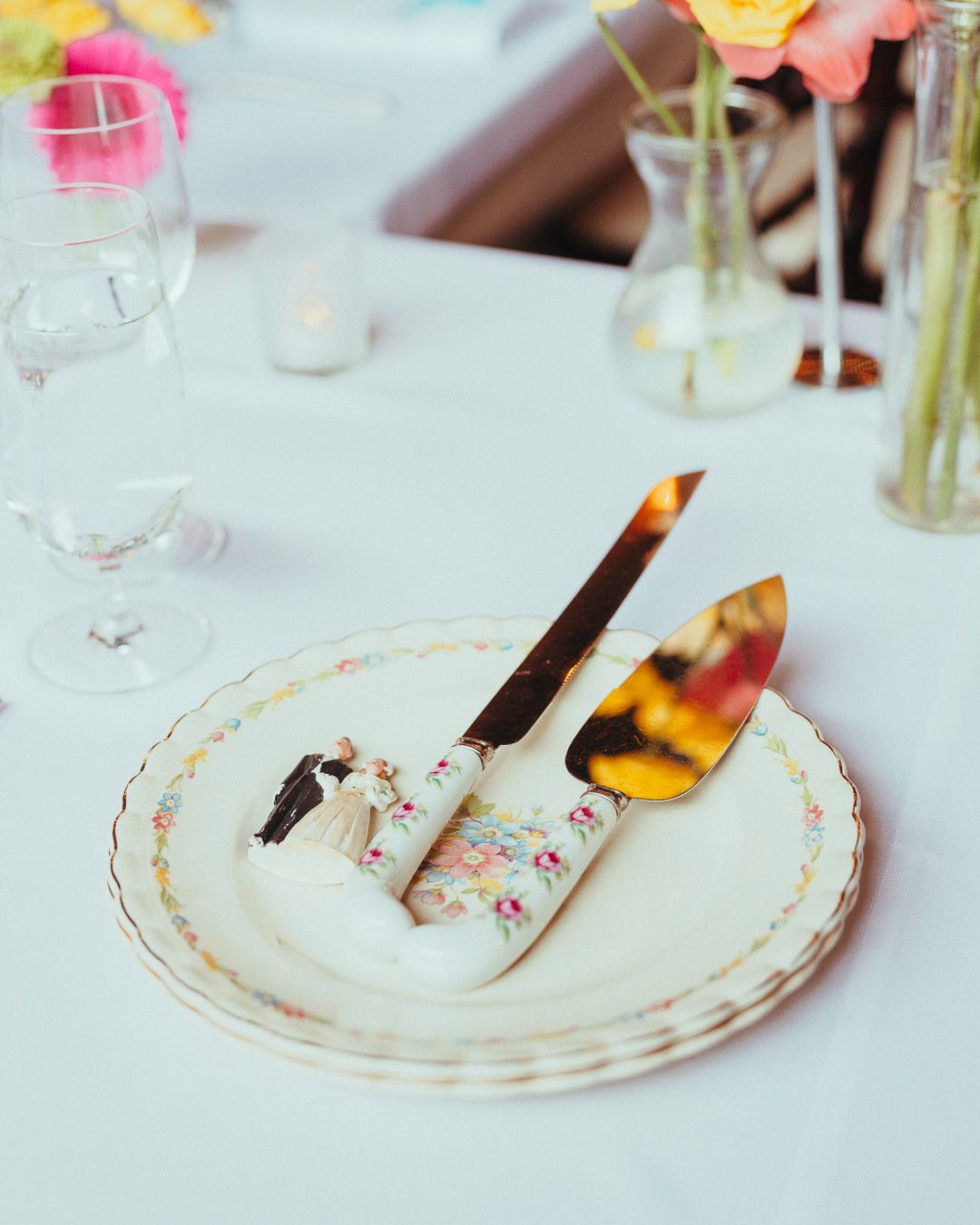 Elegant white plates with delicate gold trim and floral designs arranged on a table setting.