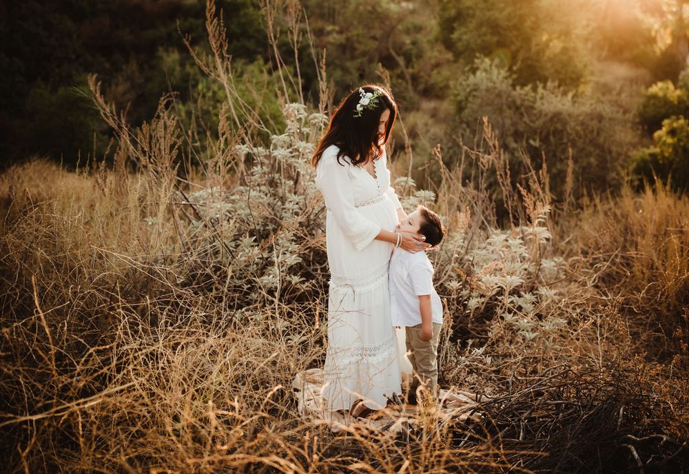A romantic sunset engagement photoshoot in a golden field with tall grass and warm autumn lighting.
