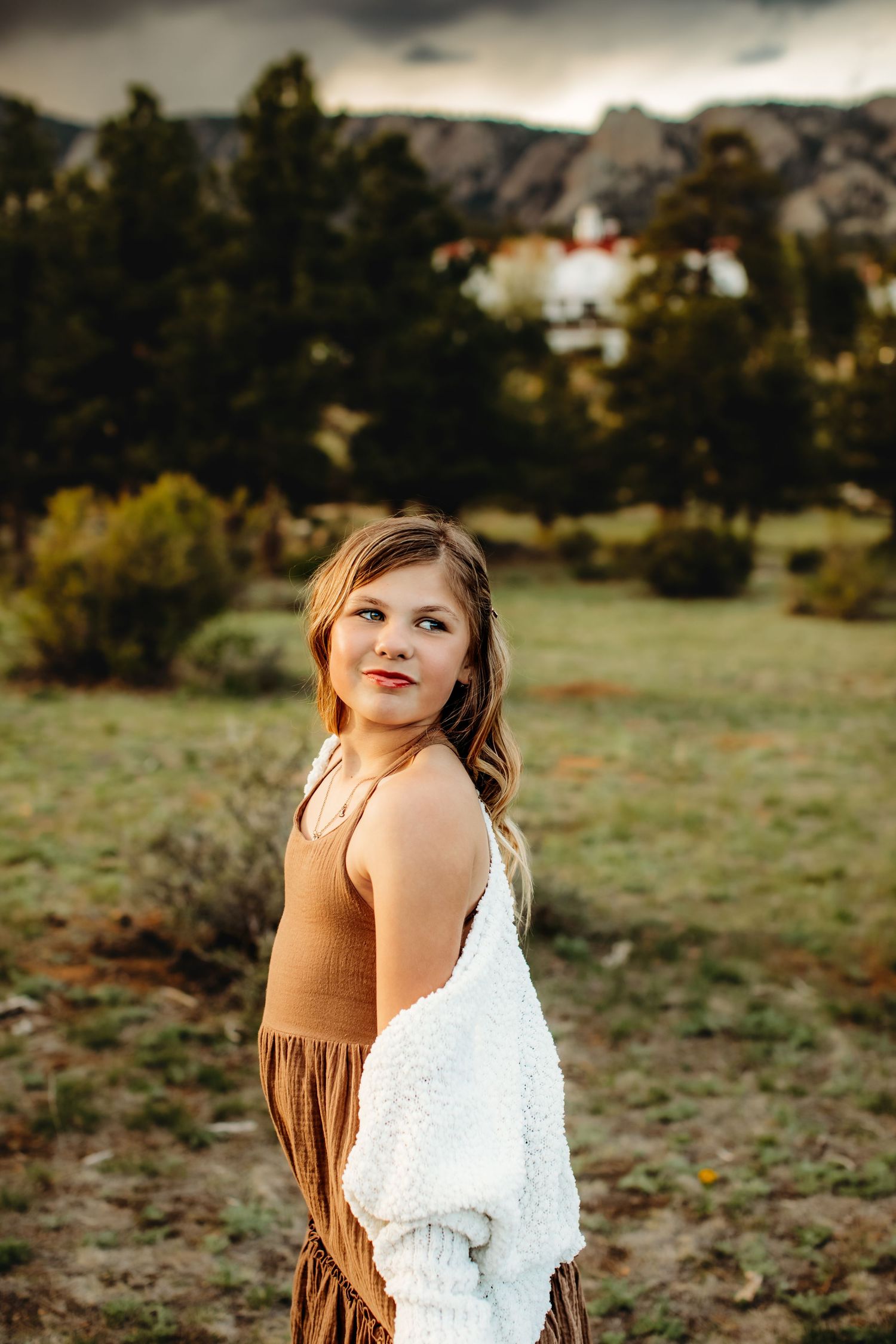 A series of outdoor portrait photos showing a person in a white lace dress and brown dress against a natural landscape setting.