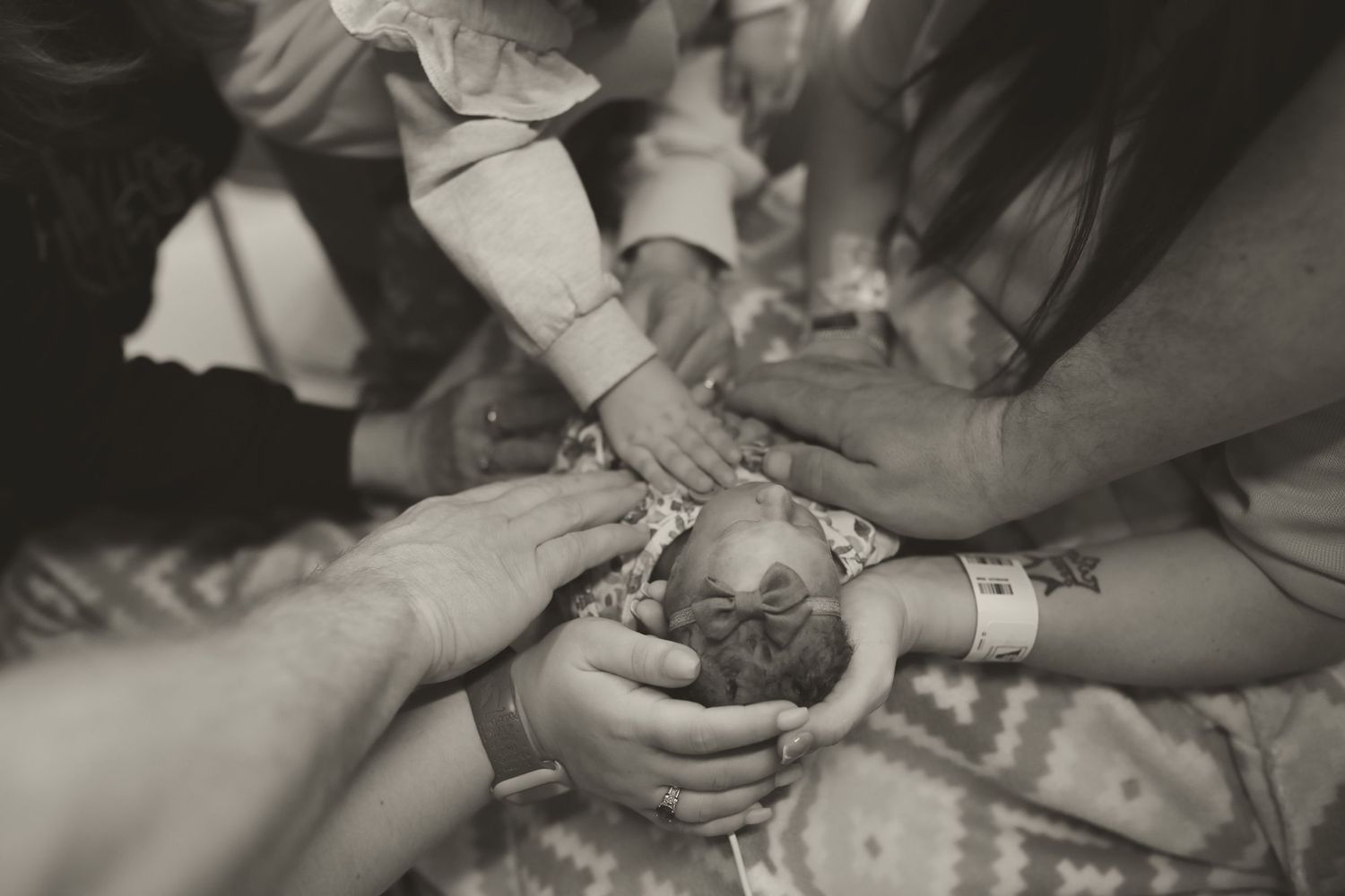 Sequence of black and white images showing hands carefully holding small baby.