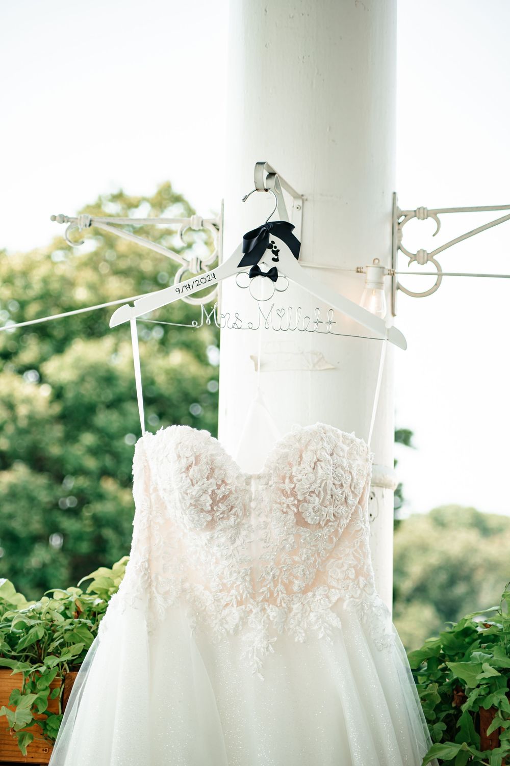 Close-up of a delicate lace wedding dress bodice hanging on display.
