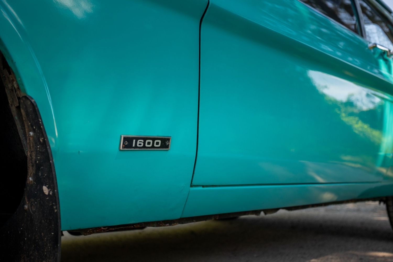A BYD Dolphin Surf headlights illuminate a dark cobblestone street at night, creating a dramatic scene.