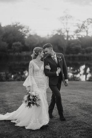 Black and white wedding photo series showing a couple on grass during sunset in romantic candid poses together.