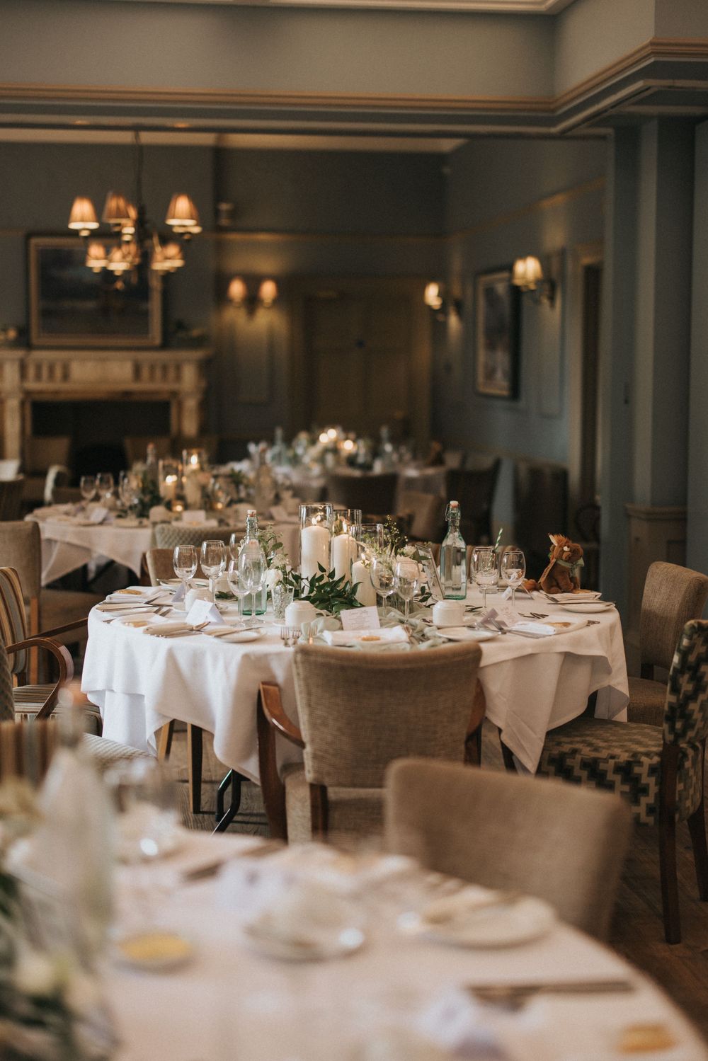 Elegant dining tables set with white linens, glassware and chairs in an upscale restaurant interior at Washingborough Hall.