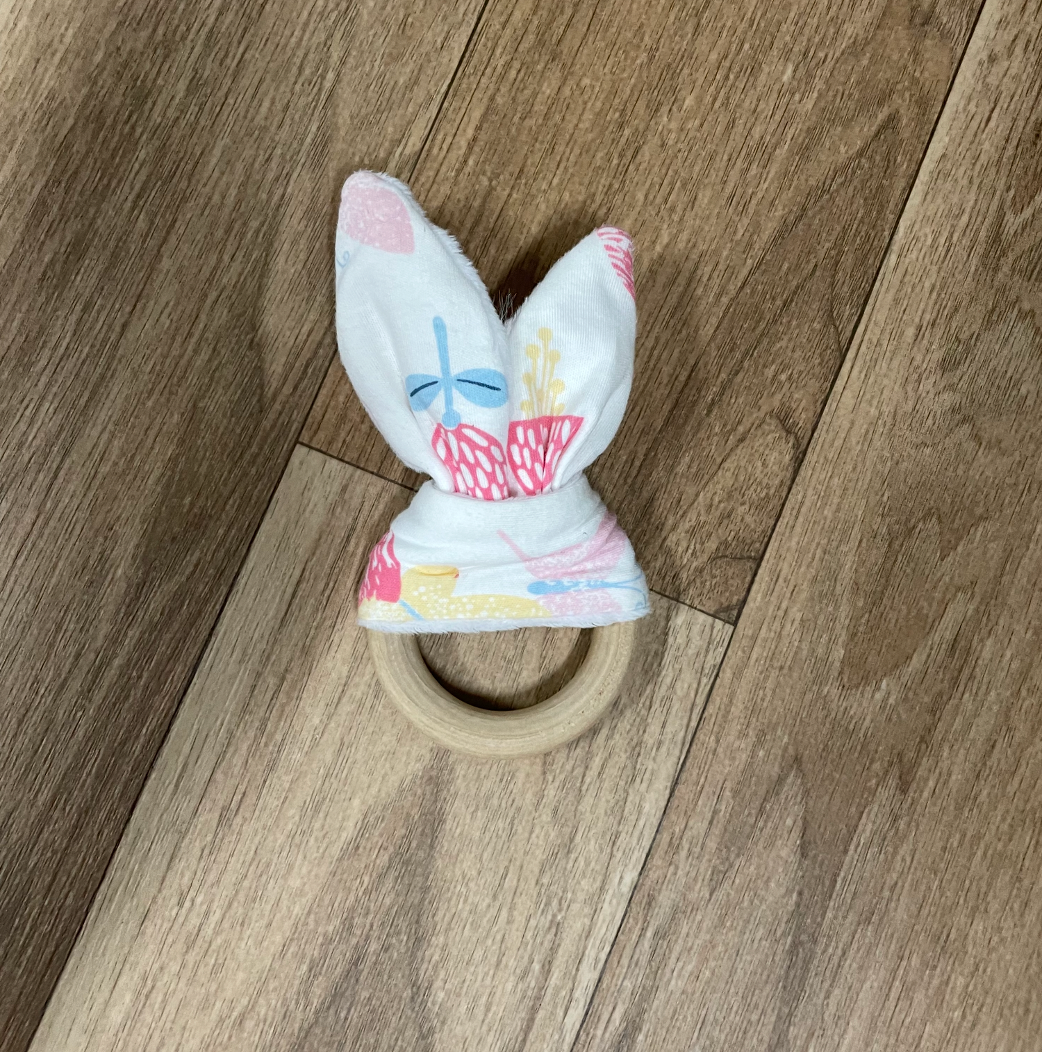 White bunny ear accessories arranged in a line on wooden floor.