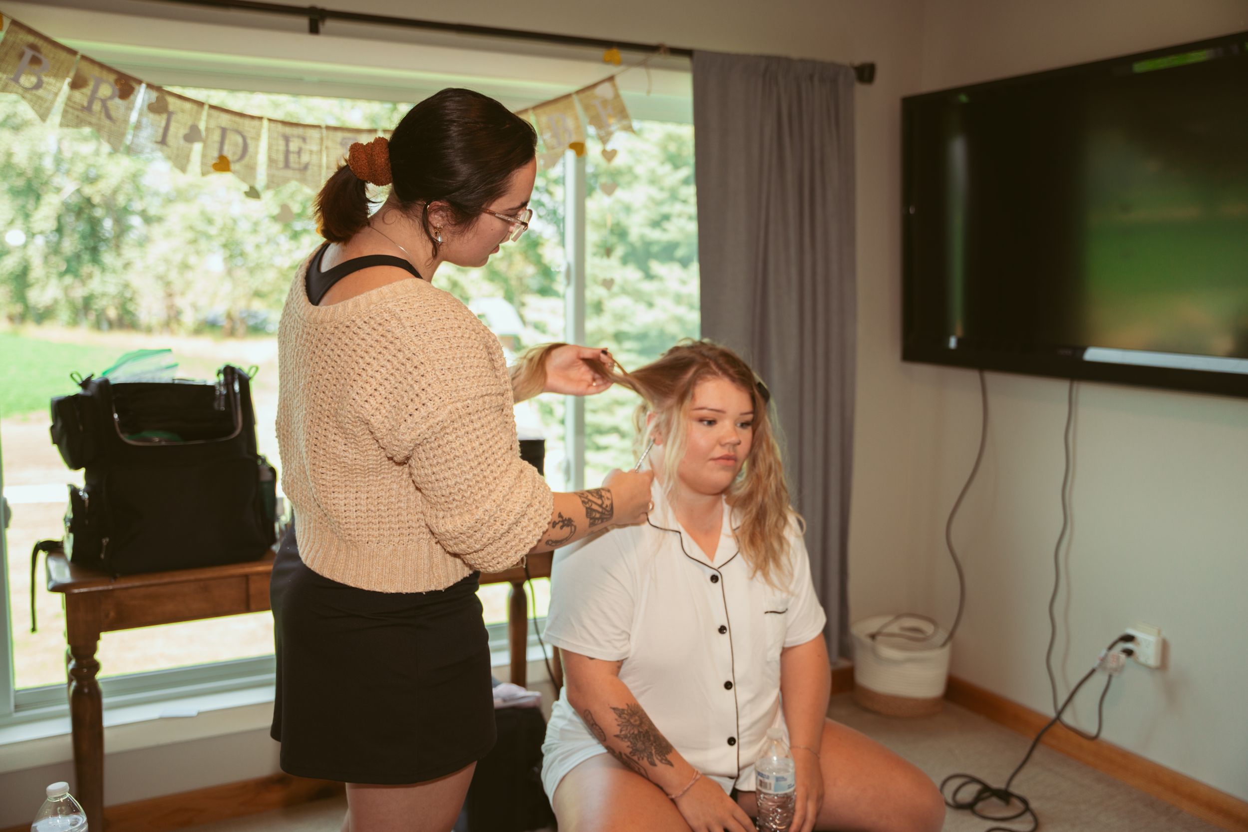 Wedding preparation scene with natural lighting showing styling and dressing moments.