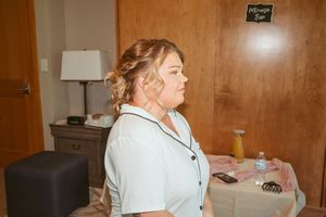 Wedding party getting ready in a room with wood paneled walls and soft lighting.