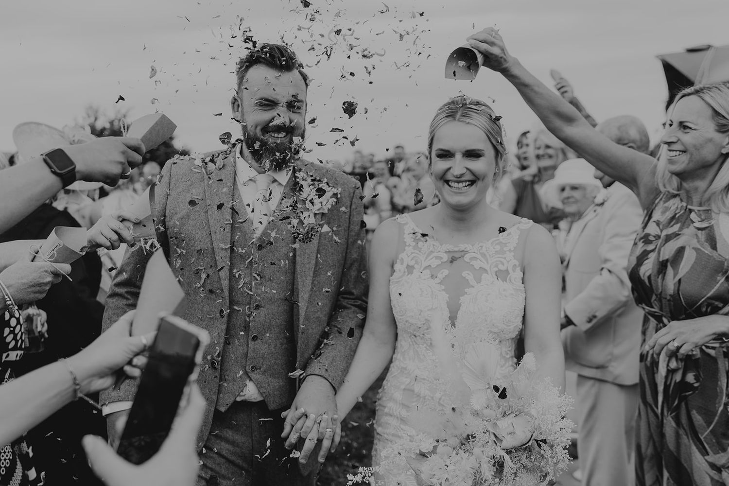 Black and white wedding photo series showing joyful celebration with confetti.