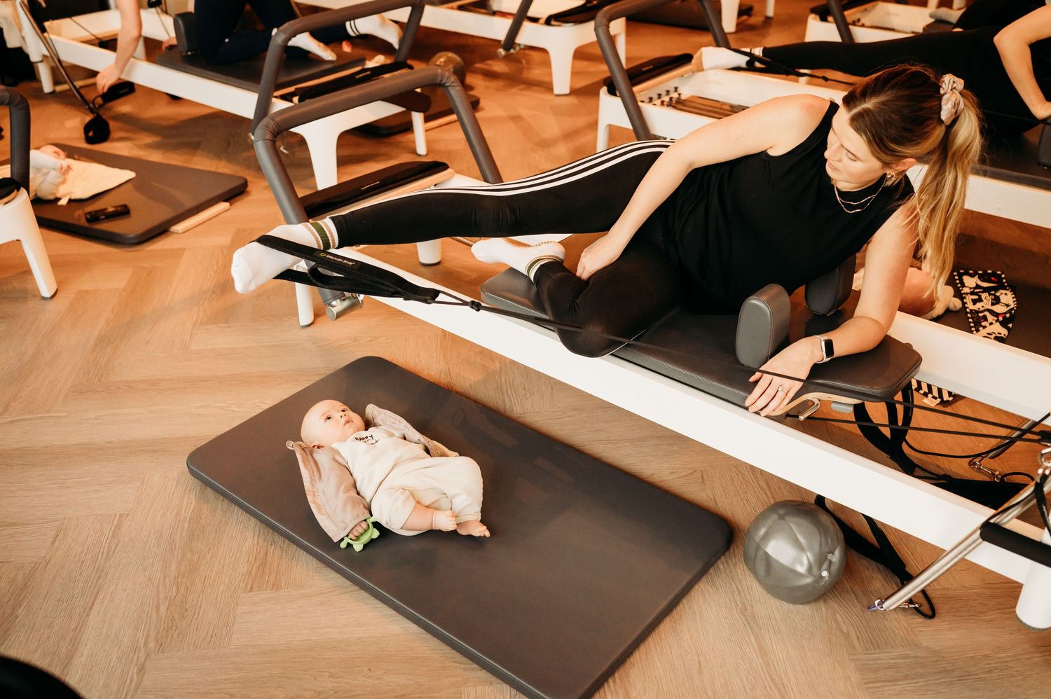 Athletes stretching and performing flexibility exercises in yoga poses at a modern fitness studio class.
