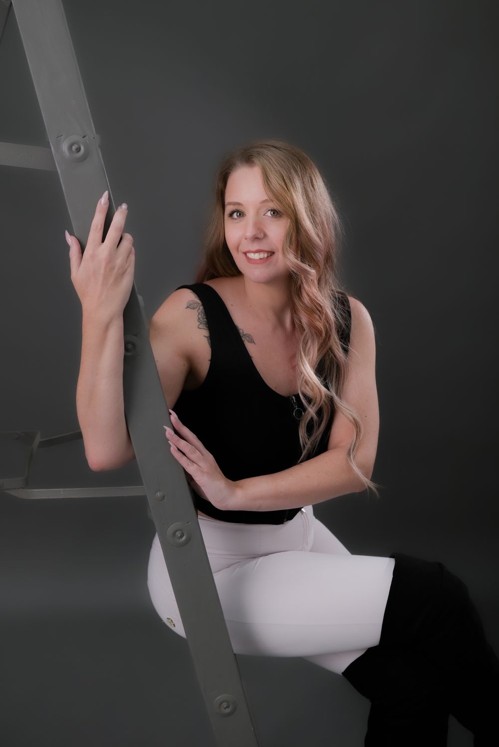 A series of playful poses against a dark background showing someone in a black and white outfit.