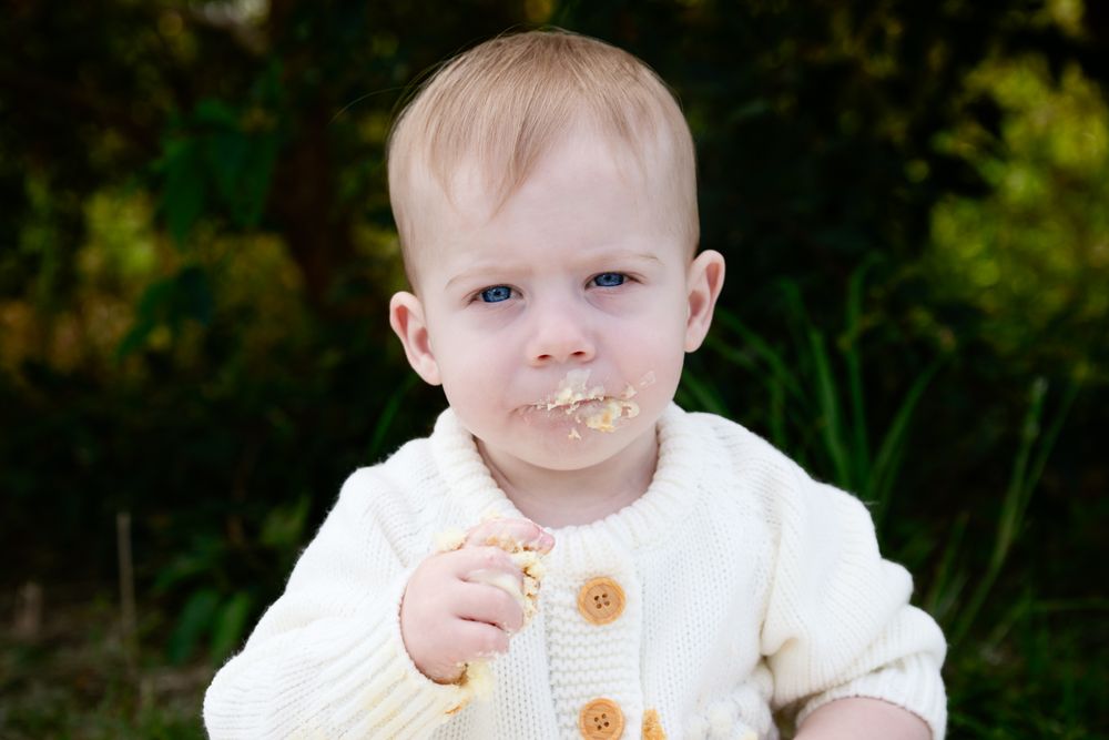 A series of connected photos showing a young child in white clothing against a green outdoor background.